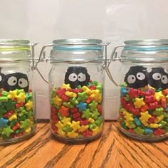 three glass jars filled with different colored candies