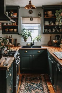 a kitchen with dark green cabinets and wooden counter tops, an area rug in front of the sink