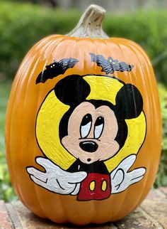 a mickey mouse pumpkin sitting on top of a wooden table