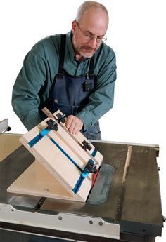 a man in an apron is working on a piece of wood with a table saw