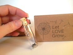 a person holding a lighter in their hand next to a box with the words let love grow written on it