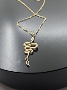 "*MAY SLIGHTLY DIFFER FROM PICTURES AS EACH ONE IS HANDMADE* *NOT PLATED OR GOLD FILLED *Pictured Next To Nickle For Size Reference 14K Solid Yellow Gold Snake Pendant With Genuine G.I.A Graded Marquise Cut Diamond Set In 14K White Gold Bezel As A Rattle Has Diamond-Cut Finish On Snake Diamond cuts are a jeweler's finish to make the outer metal surface glisten. Diamond Specs: 4 x 2 mm Marquise Cut Genuine Diamond Grade: SI2 - SI3 Color: G-H Weight: 0.068 CT TWT Cut: Marquise Faceted G.I.A Graded Luxury Gold Snake-shaped Jewelry, Luxury Gold Snake Shaped Jewelry, Luxury Yellow Gold Snake Necklace, Gold Snake-shaped Engraved Necklace, Gold Snake Necklace With Engraving, Gold Engraved Snake Necklace, Formal Gold Snake Jewelry, Snake Pendant, Snake Necklace