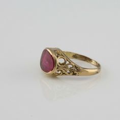 10K Yellow gold Ruby Synthetic Ring, cushion shaped stone, bezel set wear commensurate with age, S and C curls, cutouts to sides, 3/8 inch across, ring size 5.5, Circa 1920, 2.13 grams SKU# BB280R21 This listing contains photographs of the actual item you will receive. Our items are in excellent condition with little or no signs of wear and many are one of a kind pre-owned estate finds. Please look closely at the pictures in this listing as they are part of the product description. Please read t Antique Cushion Cut Rings For Formal Occasions, Antique Gold Ruby Ring With Bezel Setting, Antique Cushion Cut Anniversary Rings, Vintage Cushion Cut Rings For Formal Occasions, Vintage Cushion-cut Rings For Formal Events, Antique Yellow Gold Ruby Ring With Filigree, Heirloom Gold Cushion Cut Ring, Vintage Cushion Cut Ring For Gift, Vintage Cushion Cut Rings For Gift