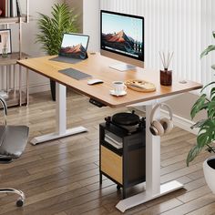 a computer desk with a laptop on top of it next to a potted plant