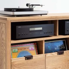 a record player and some books in a wooden cabinet