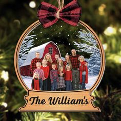 a christmas ornament with an image of a family in front of a barn