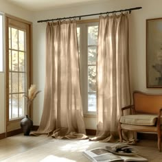 a living room filled with furniture and windows covered in beige draping next to a window