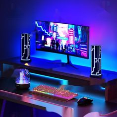 a computer desk with a keyboard, mouse and monitor lit up in blue light at night