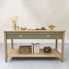 a wooden table with two drawers and some books on it, in front of a white wall