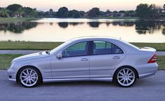 a silver car parked in front of a lake