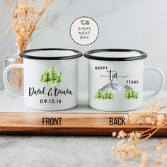 two personalized coffee mugs on a wooden tray with flowers and dried plants in the background