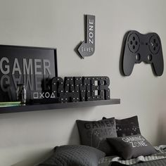 a bed with pillows and two video game controllers mounted to the wall