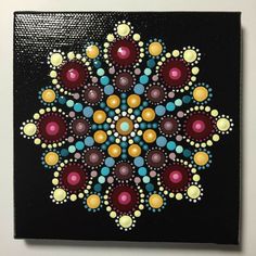 a colorful painting on a black background with circles and dots in the center, as well as an abstract design