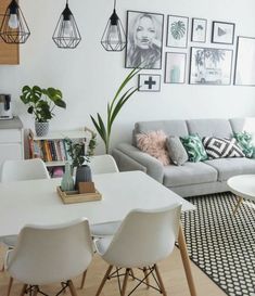 a living room filled with white furniture and pictures on the wall above it's coffee table