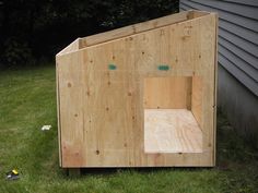 a wooden box sitting in the grass next to a house