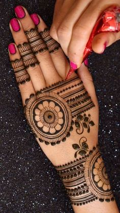 a woman's hand with henna tattoos on it