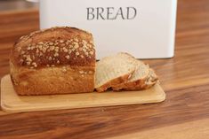 a loaf of bread sitting on top of a wooden cutting board next to a box