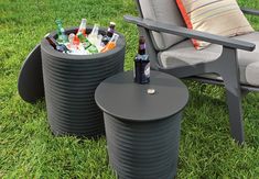 two chairs and a table with beer bottles in them on the grass next to a lawn