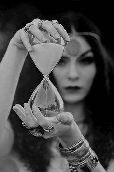 a woman holding an hourglass in her hand