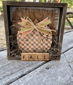 a wooden block with the word fall written on it in front of a small box