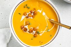 two bowls filled with soup and garnished with croutons on the side