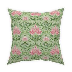 a green pillow with pink flowers and leaves on the front, sitting on a white background