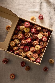 a box filled with small red and yellow flowers on top of a white table cloth