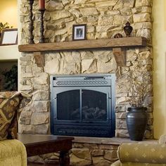 a living room with a fire place and couches in front of a stone fireplace