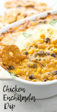 a casserole dish filled with cheese and black olives, topped with a tortilla chip