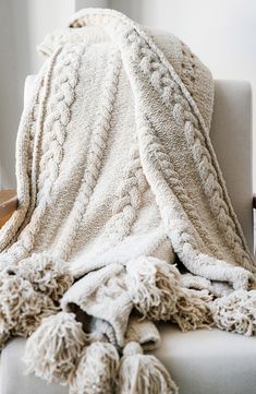 a white blanket sitting on top of a chair