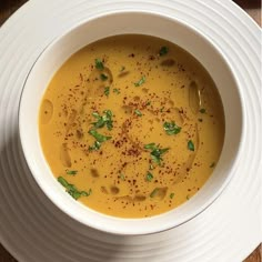 a white bowl filled with soup on top of a wooden table