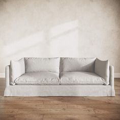 a white couch sitting on top of a hard wood floor