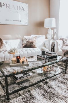 a living room filled with furniture and a glass coffee table on top of a rug