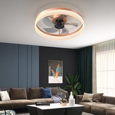 a living room with couches, tables and a ceiling fan in the middle of it