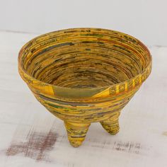 a small yellow bowl sitting on top of a wooden table next to a white wall