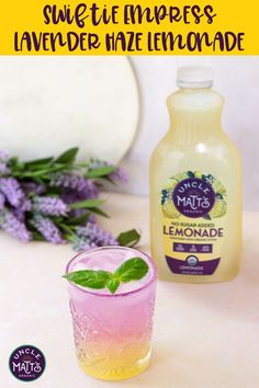 a bottle of lemonade next to a glass filled with lemonade and mint leaves