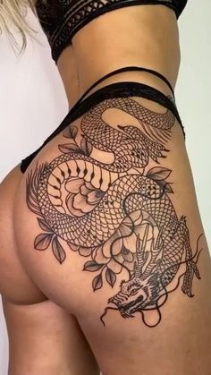 a woman's thigh with a tattoo design on the side and an image of a dragon