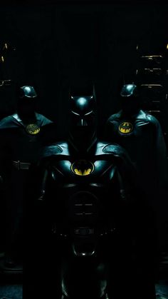 the dark knight batman costume is shown in front of several other men wearing black suits