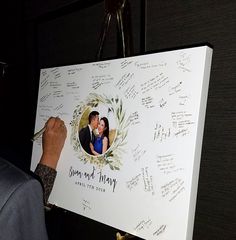 a man writing on a large white board