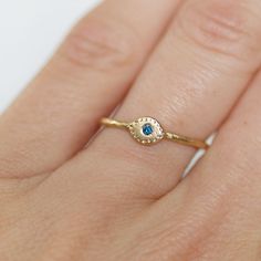 "Sparkly teal blue diamond \"Evil Eye\" ring. Diamond - 1.7mm - conflict-free, teal blue (treated to enhance color) Band - Hammered gold band...choose between 1.3mm and 1.6mm thickness Eye - 4mmx6mm Gold - 14k (18k Gold available. Pricing on request) Size - Please leave your ring size in the \"message to seller\" section at checkout **When you check out, choose: 1.3mm or 1.6mm band width...if you are stacking with one of my 1.6mm bands, choose the 1.6mm. If you are stacking it with one of my 1.3 Turquoise Sapphire Ring For Anniversary, Turquoise Sapphire Gemstone Promise Ring, Blue Emerald Ring For May Birthstone, Round Shape, Blue Emerald Ring For May Birthstone, Turquoise Sapphire Promise Ring, Blue Emerald Ring In 14k Gold, Blue 14k Gold Birthstone Ring For Promise, Blue 14k Gold Birthstone Promise Ring, Blue Emerald Ring With Bezel Setting