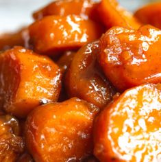 close up view of cooked carrots with sauce on them in a white bowl, ready to be eaten