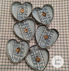 four heart shaped buttons sitting on top of a checkered tablecloth covered table cloth