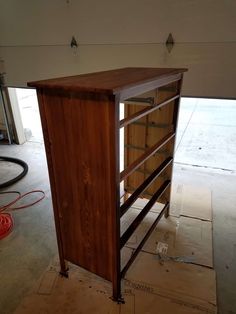 a wooden cabinet sitting on top of a hard wood floor