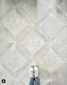 a person standing in front of a tiled floor with their feet up on the ground