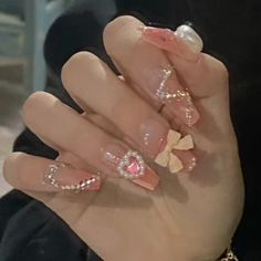 a woman's hand with pink and gold nail polish