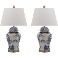 two blue and white vases with lamps on them