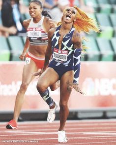 a woman running on a track with her mouth open