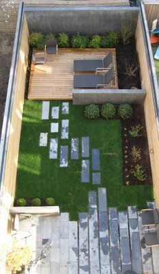 an aerial view of a small backyard with grass and wooden steps leading up to the deck