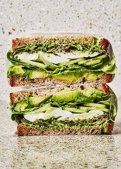 two sandwiches stacked on top of each other with lettuce and mayonnaise