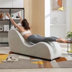 a woman sitting in a chair with her feet up on the floor and arms outstretched